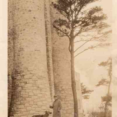1927 ca JHHJr with dog at base of oceanside tower,