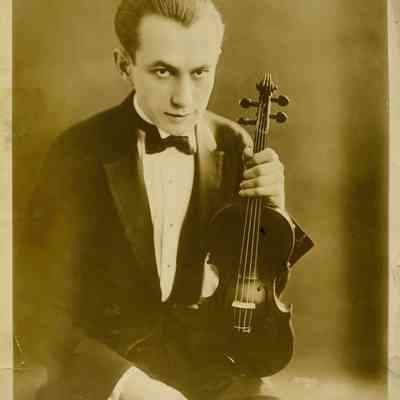 Jascha Heifetz holding violin (Apeda N.Y.)