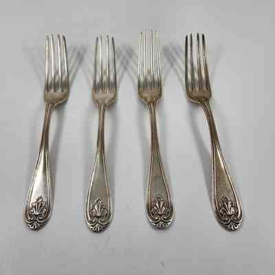Set of four silver dinner forks with leaf design on handles