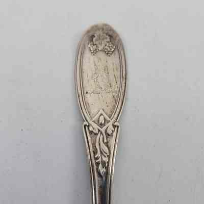 Handle of spoon with grape and vine design and a squirrel engraving
