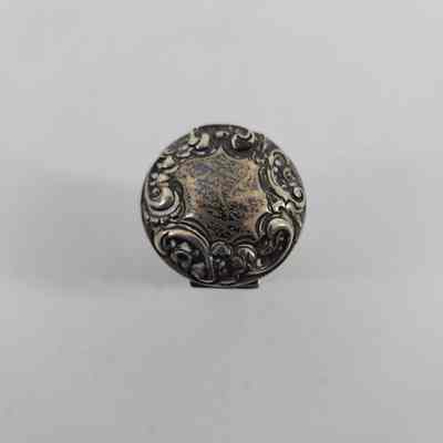 Top down view of silver lid with floral engraving