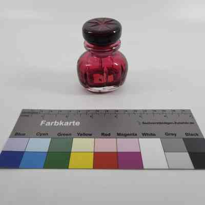 Cranberry colored glass ink bottle