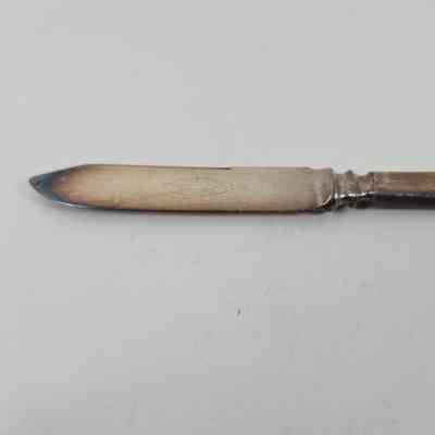 Engraving "1847 Rogers Bros Warranted" with discoloration around tip of the blade