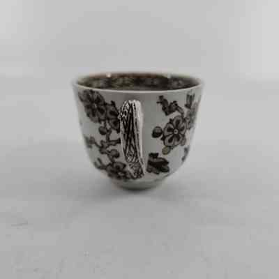 Handle with white teacup with brown floral design