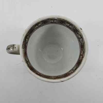 Top-down view of white teacup with brown floral design