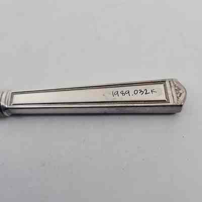 Back of silver dinner knife with accession number