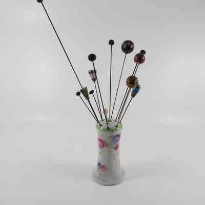 Hatpin in holder (1987.001) with other associated hatpins (1986.557 A-M)