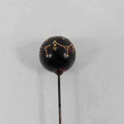 Black pinhead with golden decoration