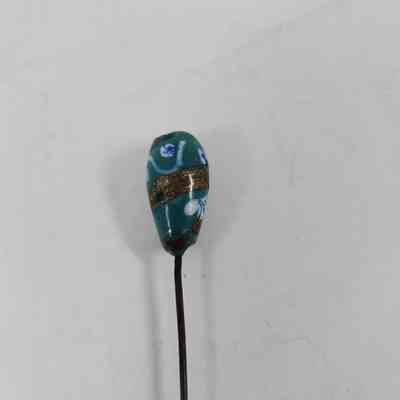 Turquoise pinhead with blue, gold and white decoration