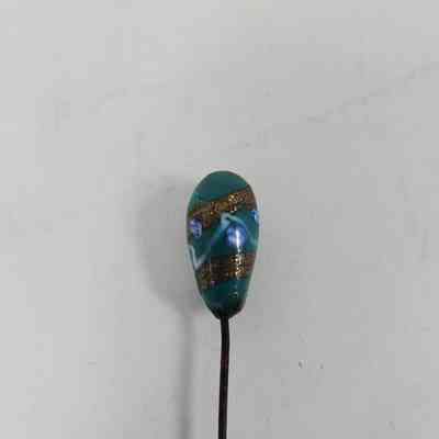 Turquoise pinhead with blue, gold and white decoration
