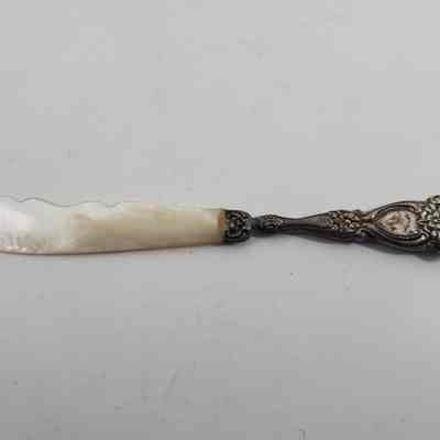 Reverse of silver letter opener with accession number written on mother-of-pearl blade