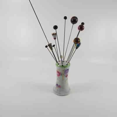 Hatpin in holder (1987.001) with other associated hatpins (1986.557 A-M)