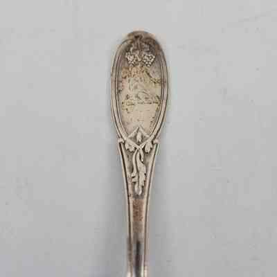 Handle of spoon with grape and vine design and a squirrel engraving