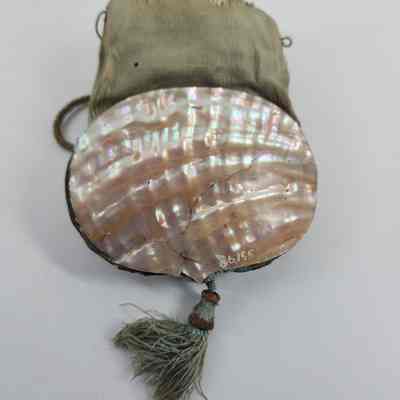 One side of green purse with crack in the shell