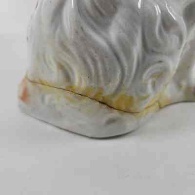 Repair of crack along the bottom of the figurine that has begun to yellow