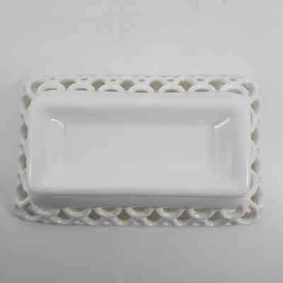 Bottom of white milk glass box with lace pattern around the rim