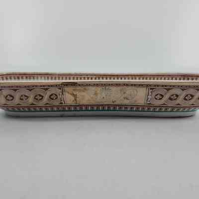 Side of soap dish with vine pattern and geometric shapes painted