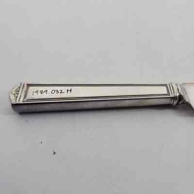 Back of silver dinner knife with accession number