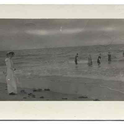 Unidentified Group of People Wading in the Surf at the Beach