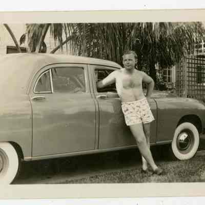 Thomas Hubbell next to car in bathing suit