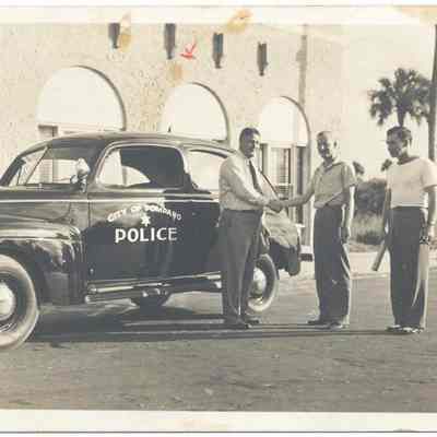 Three men beside City of Pompano police car