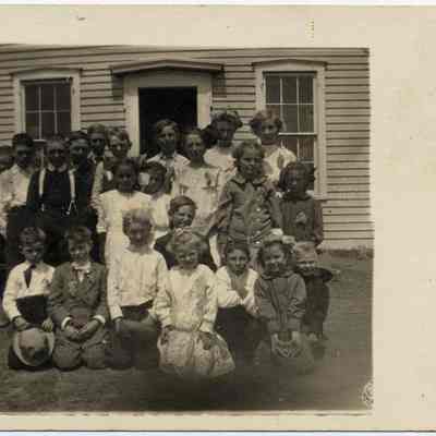 Schoolchildren posed in front of school building.