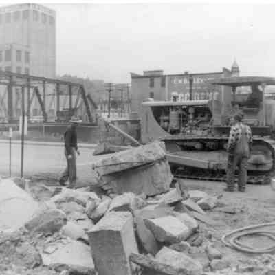 2024.14.10: Written on the back: "This is what it took to remove the old front cement steps. By the way, the guy with the hat on is one of the Rossi brothers who had the contract for the new road."