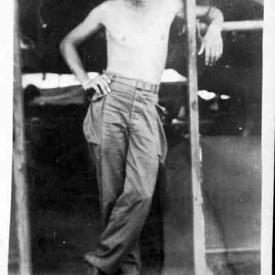 Photo of man in front of tent during WWII.