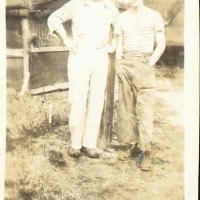 Photo of two men standing outside tent during WWII.
