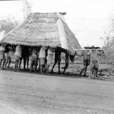 Natives carrying a roof