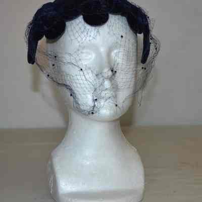Open crown velvet cocktail hat of petals and bows with veiling