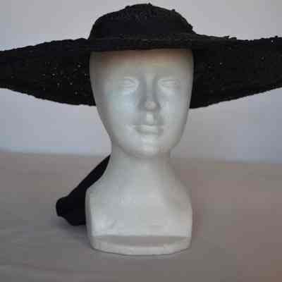 Wide brimmed straw hat with small crown, hat band with wide detail at back