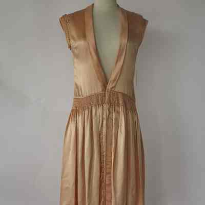 Cap sleeve dress with shirred drop waist, shawl collar and self rope embellishment