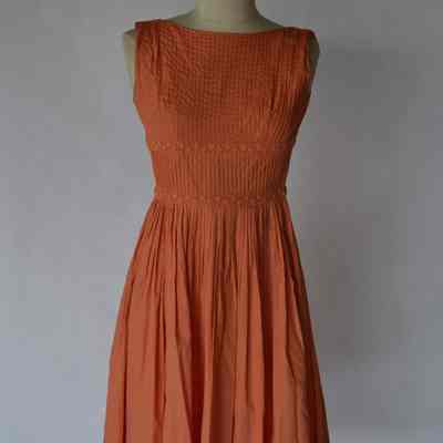 Sleeveless dress with boatneck, pintucked bodice and pleated full skirt