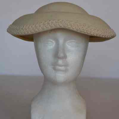 Wool felt hat with small crown and trim at edge of downturned scalloped brim