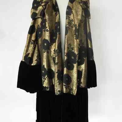 Open front long sleeve gold brocade coat with black velvet cuffs and hem and shawl collar