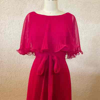 Sleeveless floor length evening dress with knife pleated skirt and cape collar, self sash.