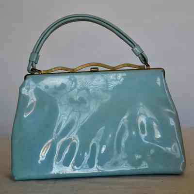 Patent leather rigid bag with decorative gold frame, self handle