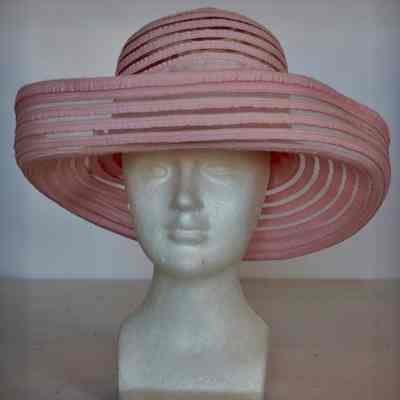 Hat with rolled up brim made of woven polyester strips with pink ribbon hat band