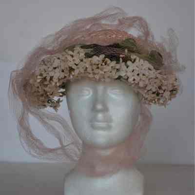 Pink straw bonnet with small white flowers and leaves