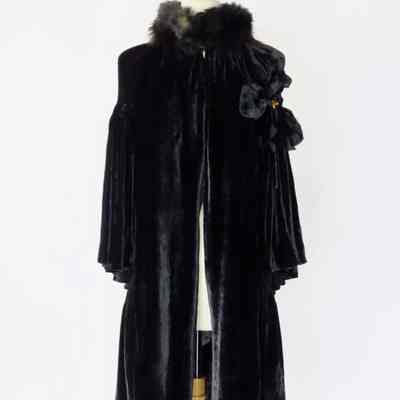 Two tiered cape with fur collar, smocking, and floral embellishment on left side