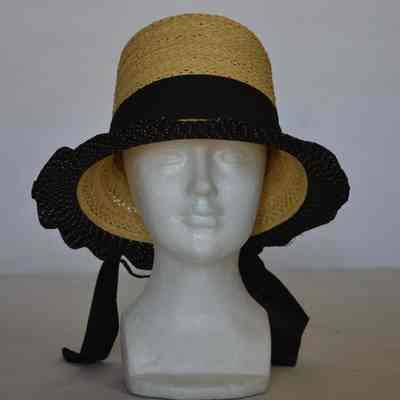 Straw brimmed hat with tall crown, black and gold fabric trim on brim, black ribbon hatband , gold colored pin on the back