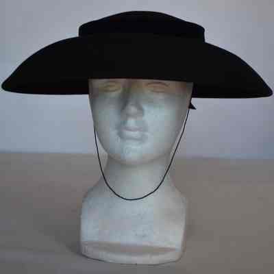 Squared crown, wide downnturned brim with velvet hatband and back bow, chin strap