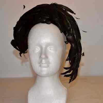 Black velvet cocktail hat with black feathers curved around crown