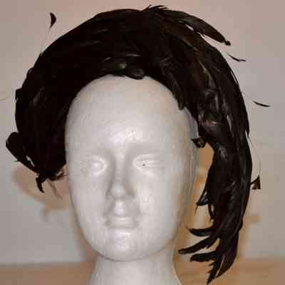 Black velvet cocktail hat with black feathers curved around crown