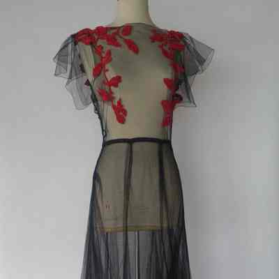 Tulle/netting over dress with chenille red flowers, slip, small matching muff, matching cap, and thin black belt