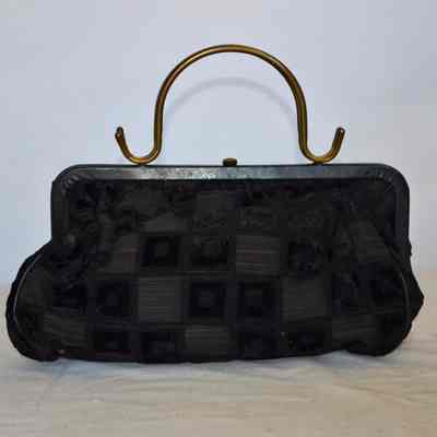 Soft textured checkerboard fabric bag with brass handle, rigid frame