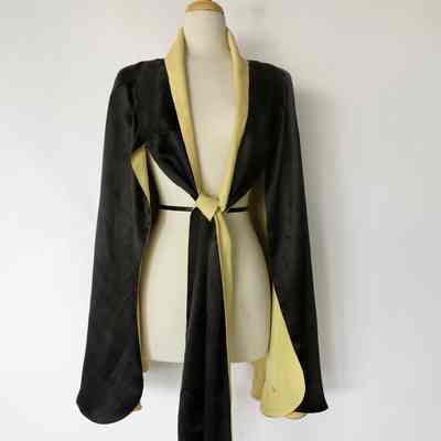 Black cape lined in cream with front sash closure