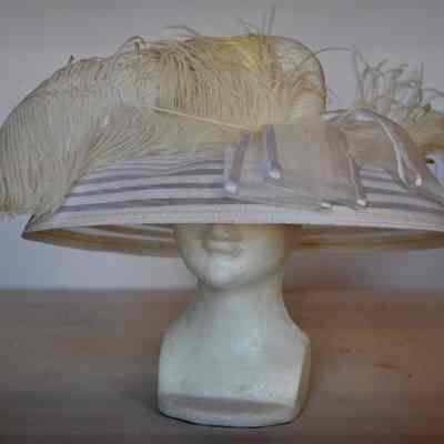 Wide brimmed bucket style hat with feather trim