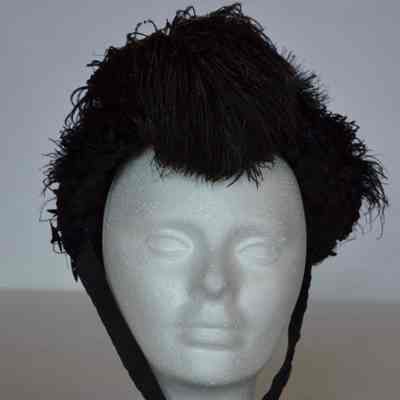 Bonnet with heavy embellishment and feathers over top, ties